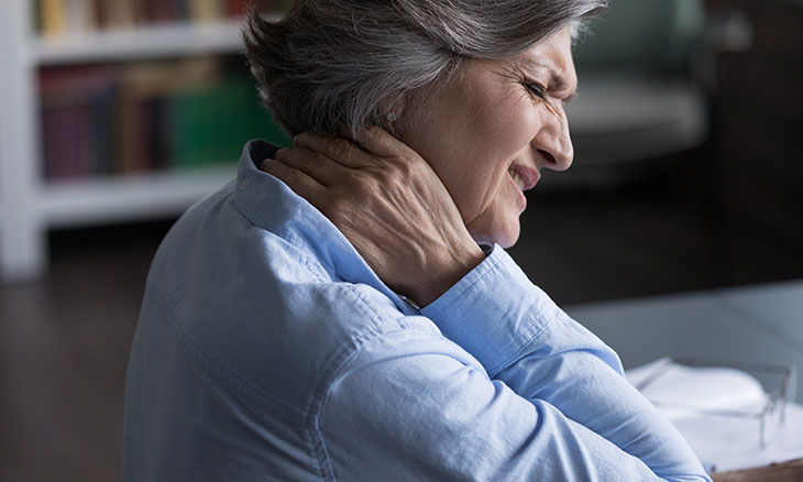 A woman holds her neck