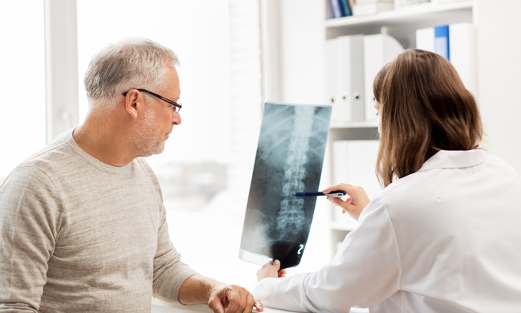 Physician showing patient x-ray of his spine